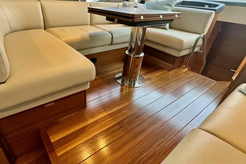 Twin Magic Yacht Photos Pics Luxurious interior of 2025 Princess F50 yacht with wooden flooring and beige seating.