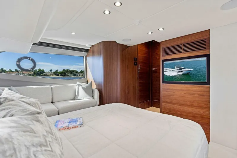 Twin Magic Yacht Photos Pics Luxurious 2025 Princess F50 yacht interior with cozy bedroom, sofa, and scenic window view.