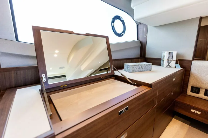 Twin Magic Yacht Photos Pics Luxurious interior of 2025 Princess F50 yacht with elegant wooden cabinetry and mirror.