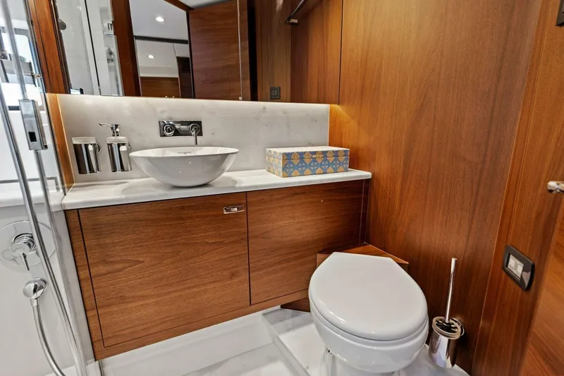 Twin Magic Yacht Photos Pics Luxurious yacht bathroom with wooden cabinetry, modern sink, and toilet. Princess F50, 2025 model.