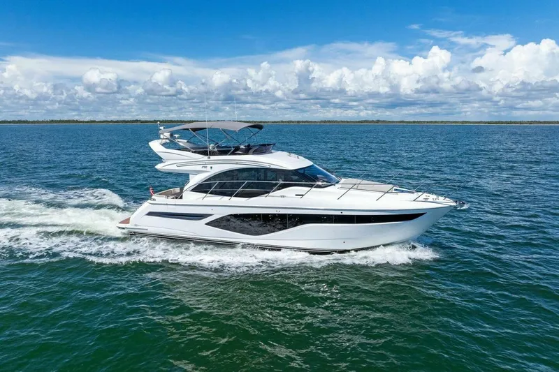 Twin Magic Yacht Photos Pics 2025 Princess F50 yacht cruising on open water under a clear blue sky.