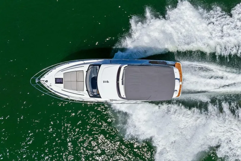 Twin Magic Yacht Photos Pics Aerial view of 2025 Princess F50 yacht cruising on green water.