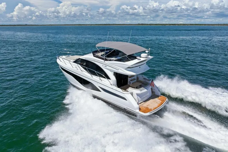 Twin Magic Yacht Photos Pics Luxurious 2025 Princess F50 yacht cruising on open water under a clear sky.