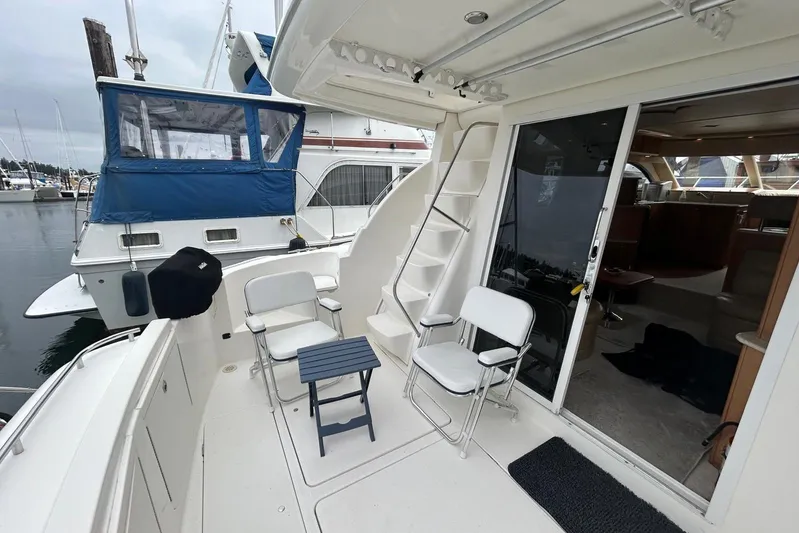  Yacht Photos Pics 2004 Meridian 411 Sedan yacht deck with chairs and table, docked at marina.