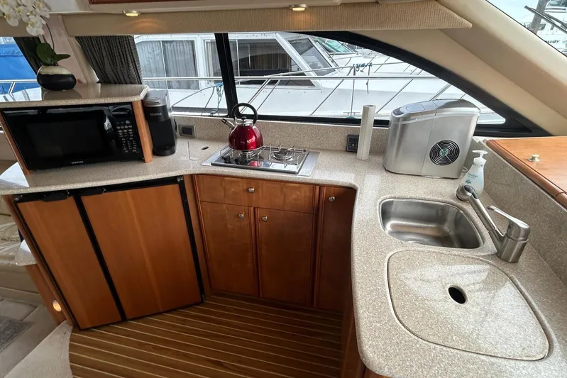  Yacht Photos Pics Compact kitchen in 2004 Meridian 411 Sedan yacht with sink, stove, and microwave.