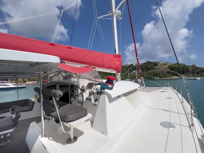 Stella Maris Yacht Photos Pics 2008 Fountaine Pajot Eleuthera 60 catamaran with red sail, docked in a scenic bay.