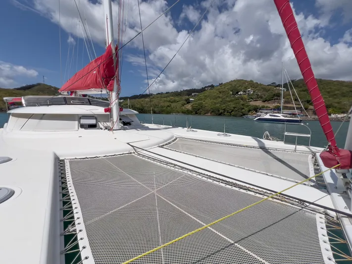 Stella Maris Yacht Photos Pics 2008 Fountaine Pajot Eleuthera 60 catamaran with red sails, docked in a scenic bay.