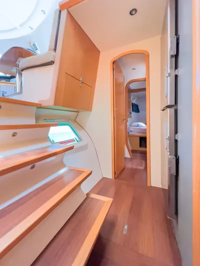 Stella Maris Yacht Photos Pics Interior of 2008 Fountaine Pajot Eleuthera 60 catamaran, featuring wooden stairs and cozy cabin.