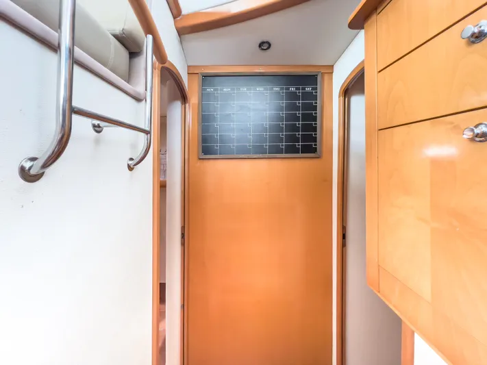 Stella Maris Yacht Photos Pics Interior hallway of 2008 Fountaine Pajot Eleuthera 60 yacht with wooden cabinetry and wall calendar.