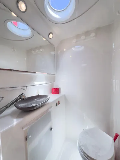 Stella Maris Yacht Photos Pics Luxurious bathroom in 2008 Fountaine Pajot Eleuthera 60 yacht with modern fixtures and porthole windows.