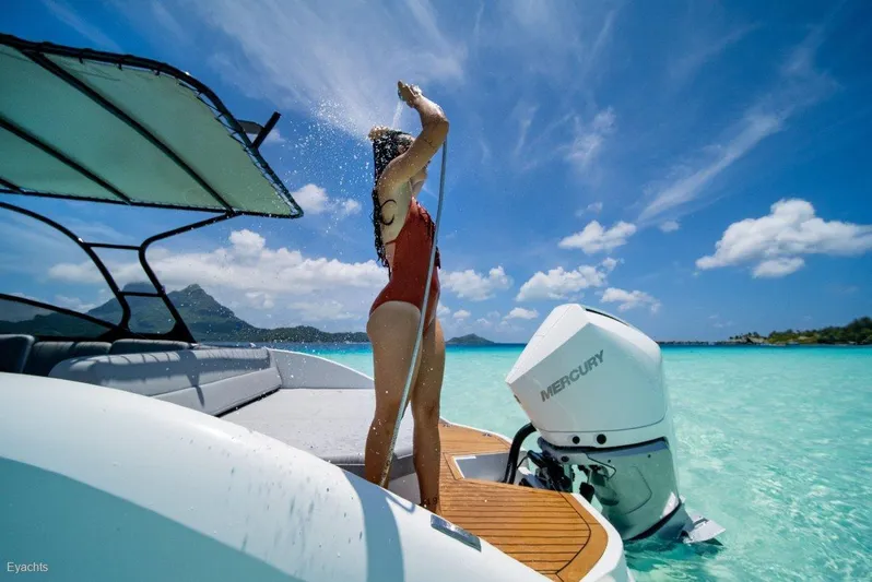  Yacht Photos Pics Woman showering on Rand Supreme 27 boat, 2025 model, in tropical waters.