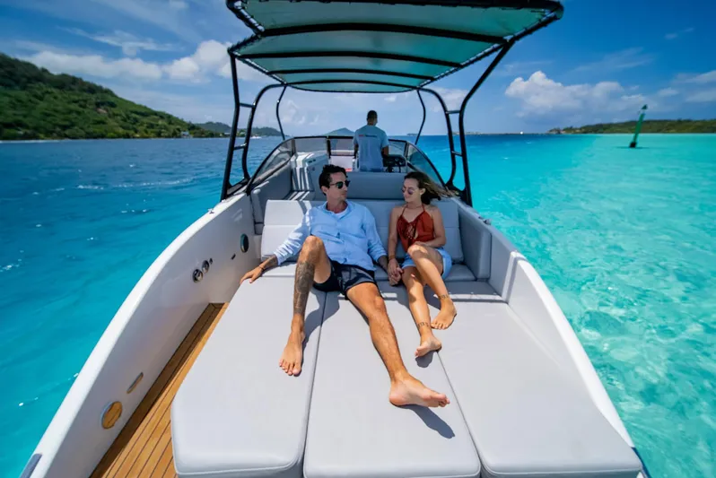  Yacht Photos Pics Couple relaxing on Rand Supreme 27 boat, 2025 model, in clear turquoise waters.