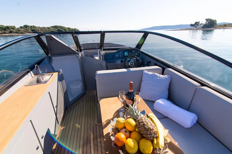  Yacht Photos Pics Luxurious 2025 Rand Supreme 27 boat interior with fruit platter and scenic water view.
