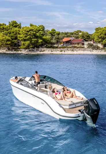  Yacht Photos Pics 2025 Rand Supreme 27 boat cruising near a scenic shoreline with passengers relaxing onboard.