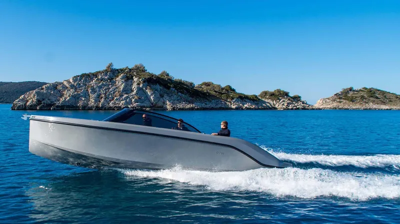  Yacht Photos Pics Modern Rand Supreme 27 boat cruising on clear blue water near rocky islands, 2025 model.
