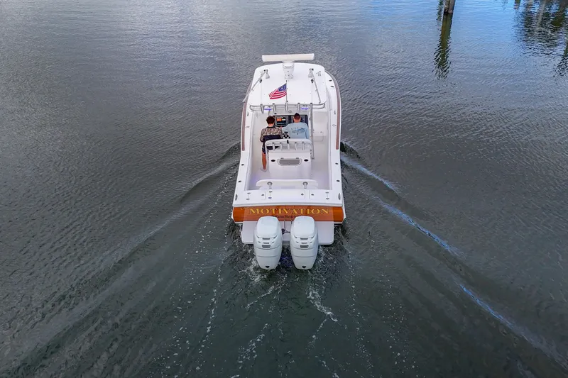 Yacht Photos Pics 2008 Buddy Davis 28 Center Console boat cruising on calm water, rear view.