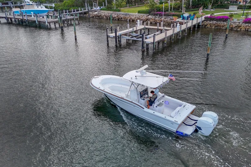  Yacht Photos Pics 2008 Buddy Davis 28 Center Console boat cruising near docks in a scenic waterfront setting.