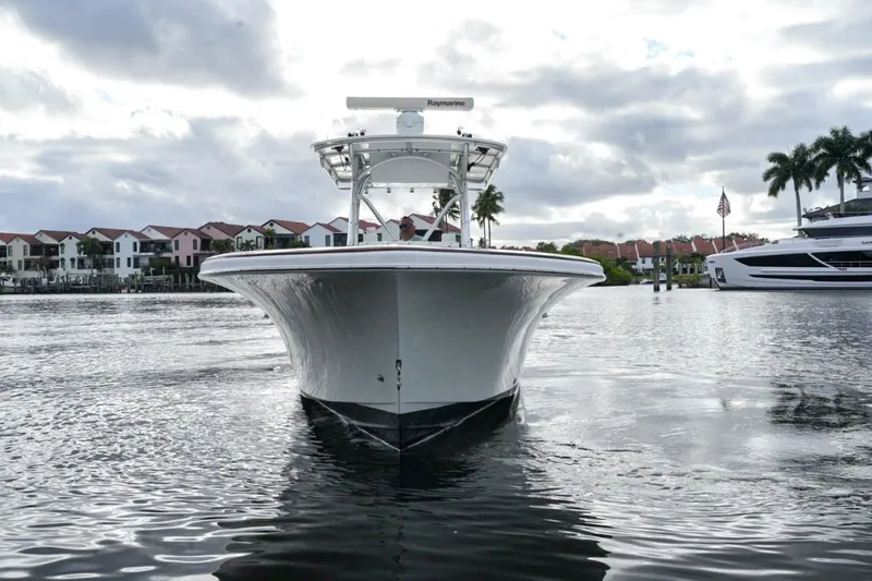 Yacht Photos Pics 2008 Buddy Davis 28 Center Console boat on calm water, with residential backdrop.