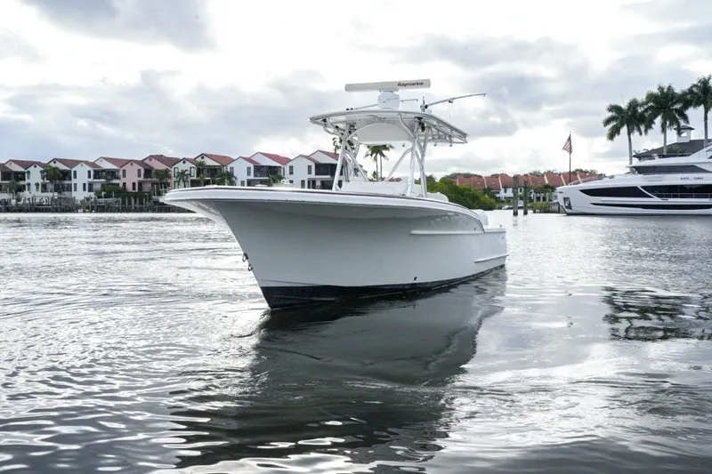  Yacht Photos Pics 2008 Buddy Davis 28 Center Console boat on calm water near waterfront homes.