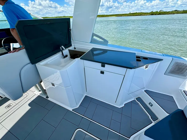  Yacht Photos Pics 2021 Aviara AV32 OB boat interior with kitchenette and sink, docked by the water.