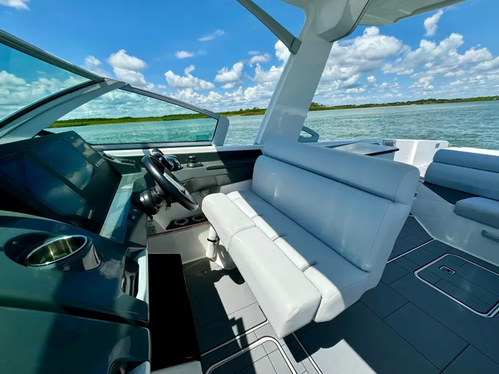  Yacht Photos Pics 2021 Aviara AV32 OB boat interior with white seating and modern dashboard on a sunny day.