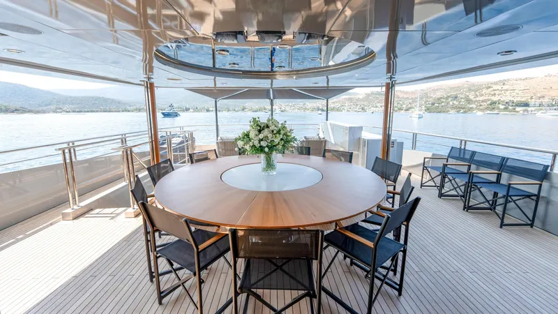 Provocateur Yacht Photos Pics Luxurious Mondomarine 50 Meters yacht deck with round table, chairs, and scenic ocean view.