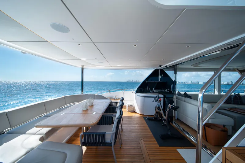 Maravi Yacht Photos Pics Luxurious 2025 Princess X80 yacht deck with ocean view, featuring dining area and exercise bike.
