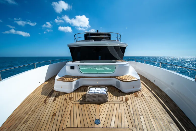 Maravi Yacht Photos Pics Luxurious 2025 Princess X80 yacht deck with jacuzzi, ocean view, and clear blue sky.