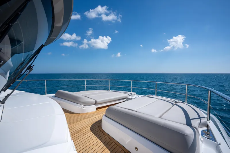Maravi Yacht Photos Pics Luxurious 2025 Princess X80 yacht deck with sun loungers, ocean view, and clear blue sky.
