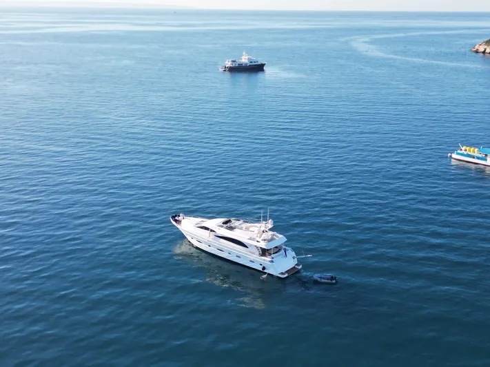  Yacht Photos Pics Astondoa 82 GLX yacht from 2000 on calm blue sea with other boats nearby.