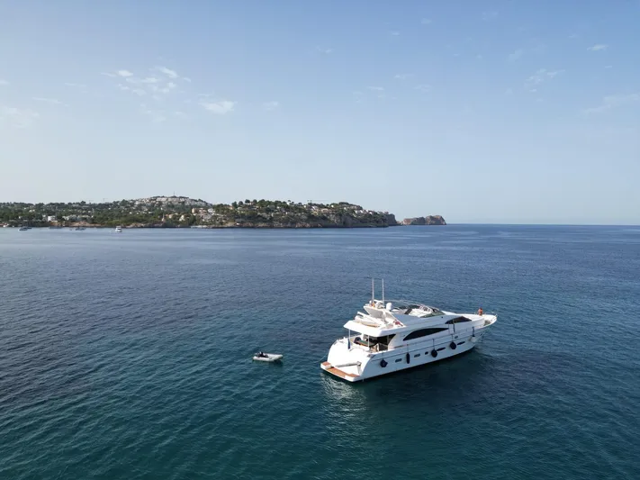  Yacht Photos Pics Luxury yacht Astondoa 82 GLX (2000) anchored in serene blue waters, distant coastline visible.