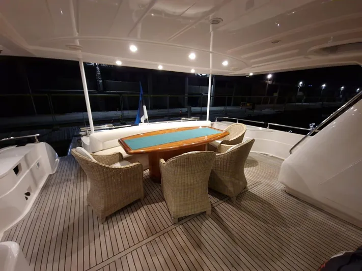  Yacht Photos Pics Luxurious outdoor dining area on 2000 Astondoa 82 GLX yacht, featuring wicker chairs and elegant table.