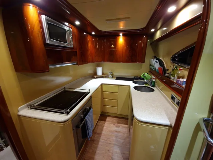  Yacht Photos Pics Luxurious kitchen interior of 2000 Astondoa 82 GLX yacht with modern amenities and wood finish.