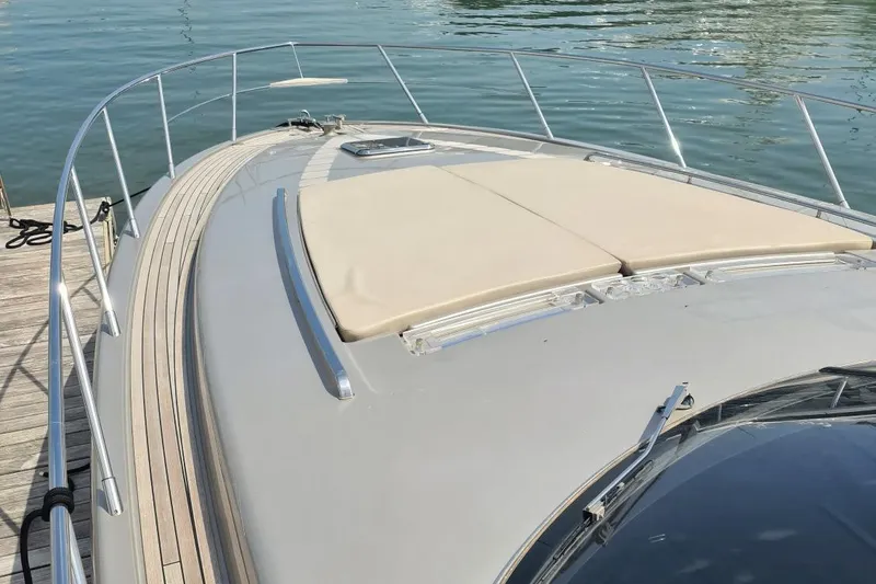 Infinity Yacht Photos Pics Luxury 2008 Riva 52 LE yacht deck with sunbathing area, docked by the water.