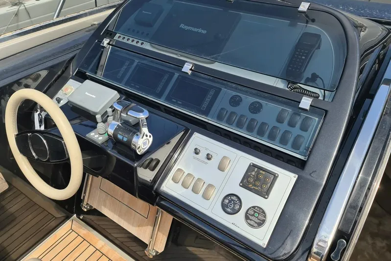 Infinity Yacht Photos Pics Control panel of a 2008 Riva 52 LE yacht with steering wheel and navigation equipment.