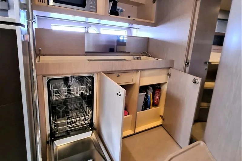 Infinity Yacht Photos Pics Modern kitchen interior of 2008 Riva 52 LE yacht with open dishwasher and cabinets.