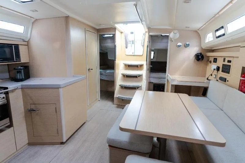  Yacht Photos Pics Modern interior of 2021 Beneteau Oceanis 40.1 yacht with kitchen and seating area.
