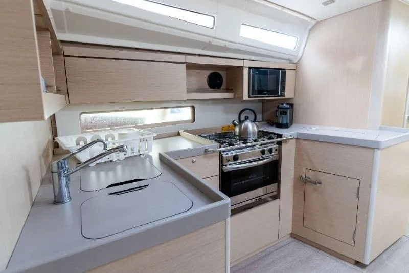  Yacht Photos Pics Modern kitchen interior of 2021 Beneteau Oceanis 40.1 yacht with stove and sink.