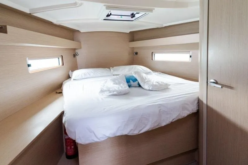 Yacht Photos Pics Cozy cabin interior of 2021 Beneteau Oceanis 40.1 yacht with comfortable bed and natural lighting.