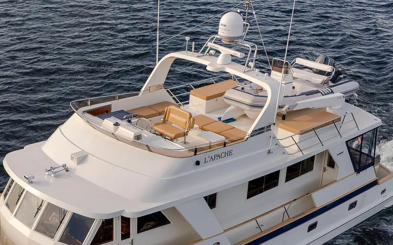 L'apache Yacht Photos Pics 2006 Alaskan 65 Flushdeck yacht cruising on water, featuring spacious deck and seating area.