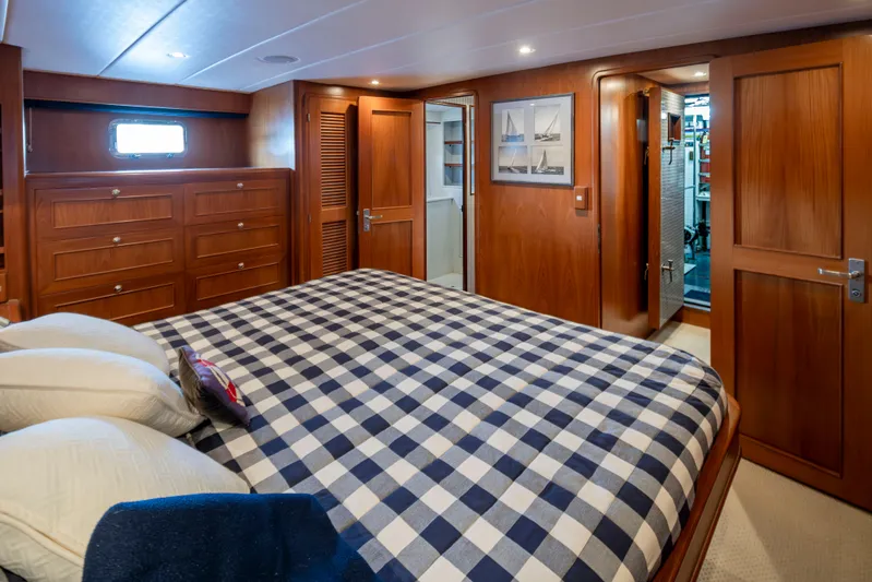 L'apache Yacht Photos Pics Luxurious cabin interior of 2006 Alaskan 65 Flushdeck yacht with checkered bedding and wooden furnishings.