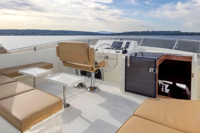 L'apache Yacht Photos Pics Luxurious 2006 Alaskan 65 Flushdeck yacht interior with seating and helm, overlooking serene waters.