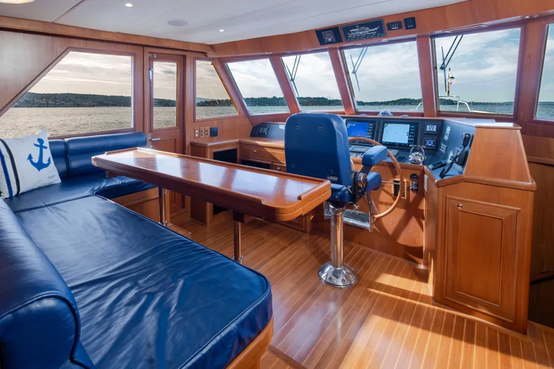 L'apache Yacht Photos Pics Luxurious interior of 2006 Alaskan 65 Flushdeck yacht with blue seating and navigation controls.