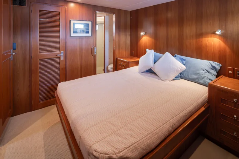 L'apache Yacht Photos Pics Luxurious bedroom interior on 2006 Alaskan 65 Flushdeck yacht, featuring wood paneling and cozy bedding.