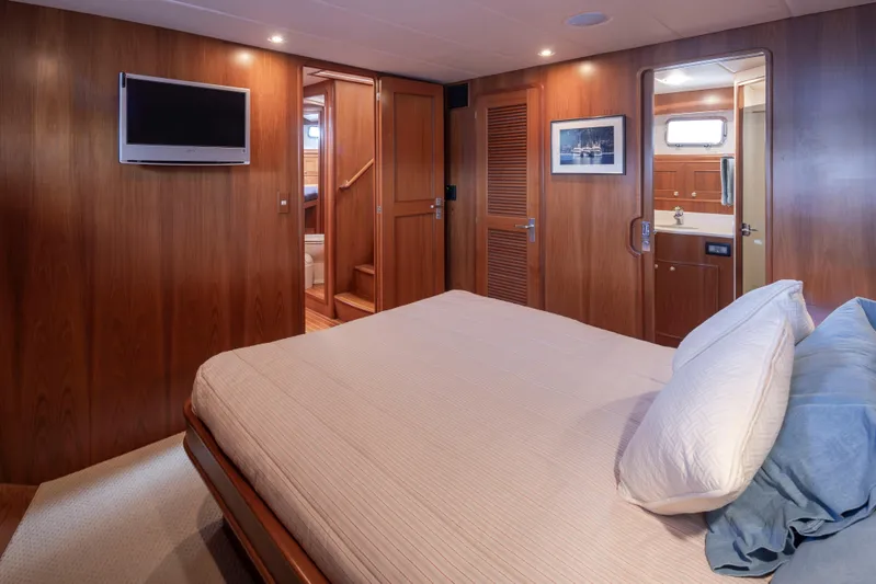 L'apache Yacht Photos Pics Luxurious bedroom interior of 2006 Alaskan 65 Flushdeck yacht with wood paneling and modern amenities.