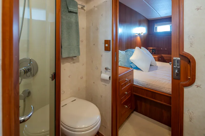 L'apache Yacht Photos Pics Bathroom and bedroom interior of 2006 Alaskan 65 Flushdeck yacht, featuring wood finishes.