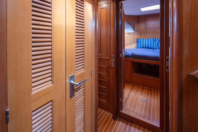 L'apache Yacht Photos Pics Luxurious wooden interior of 2006 Alaskan 65 Flushdeck yacht cabin with bed and striped pillows.