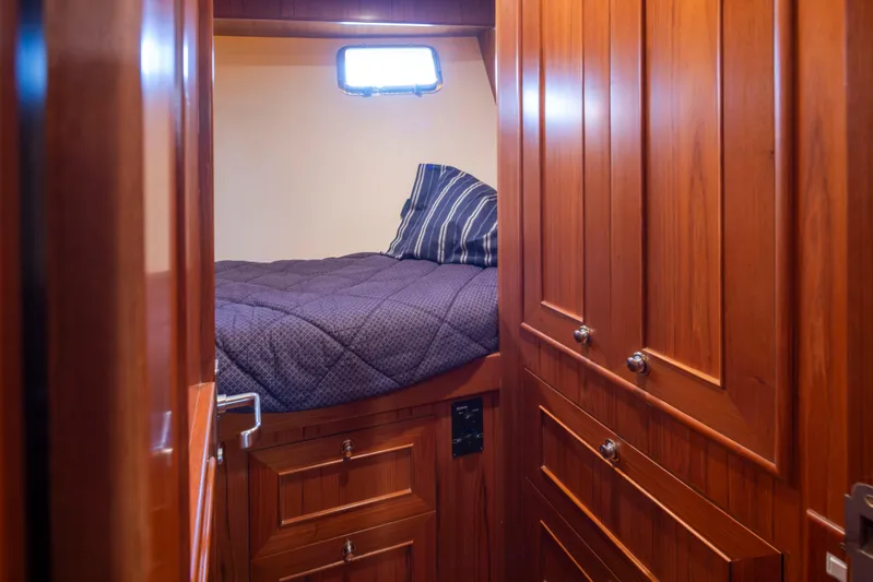 L'apache Yacht Photos Pics Cozy cabin interior of 2006 Alaskan 65 Flushdeck yacht with wooden paneling and bed.