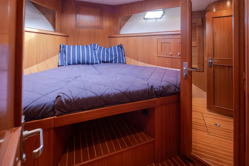 L'apache Yacht Photos Pics Luxurious cabin interior of 2006 Alaskan 65 Flushdeck yacht with wooden finish and cozy bedding.
