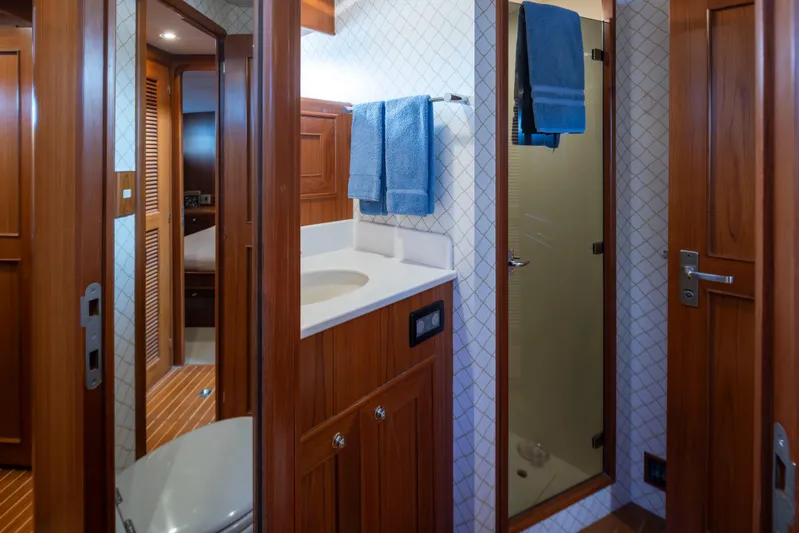 L'apache Yacht Photos Pics Luxurious bathroom in 2006 Alaskan 65 Flushdeck yacht with wooden cabinetry and modern fixtures.